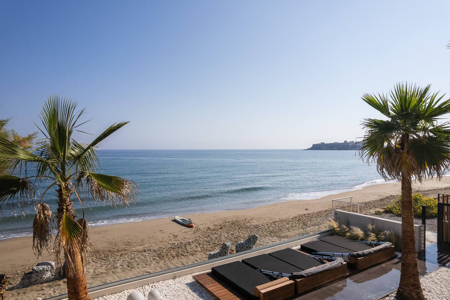 Sun loungers and palms above the beach