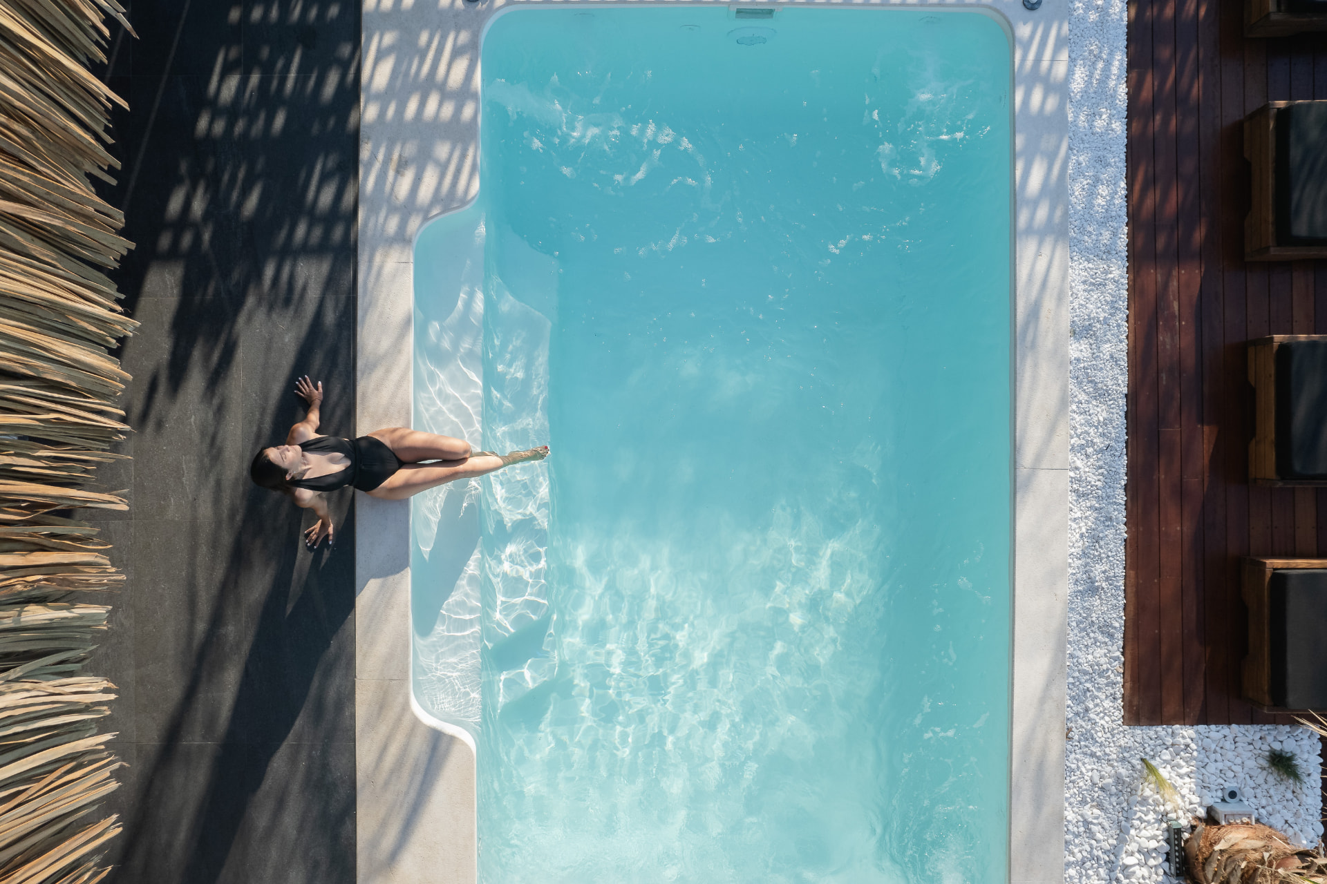 Sun loungers and palms on the pool terrace facing the sea