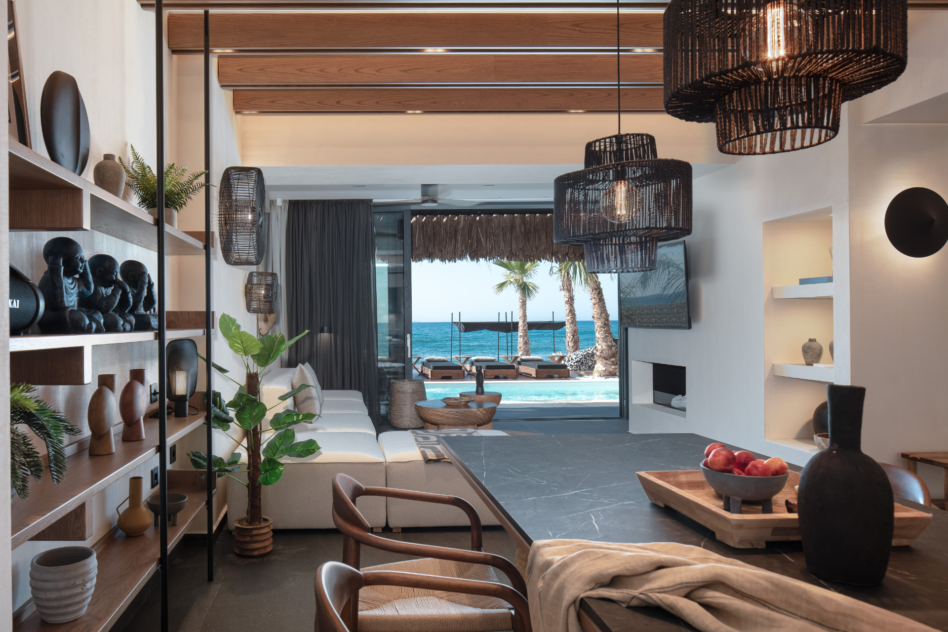 Living area with sofa, dining table and direct sea view